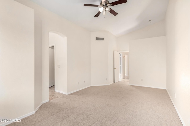 carpeted spare room with ceiling fan and vaulted ceiling