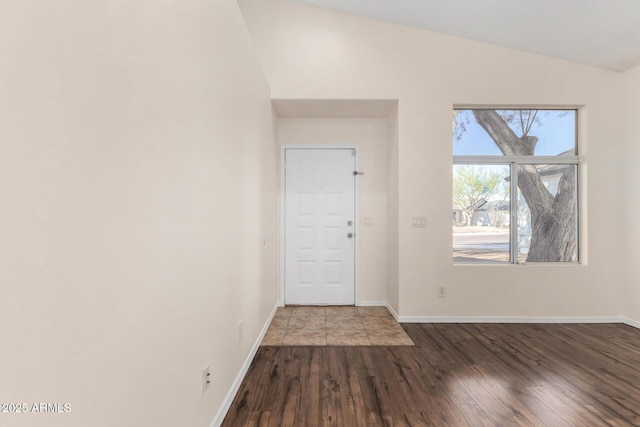 foyer with vaulted ceiling and wood-type flooring