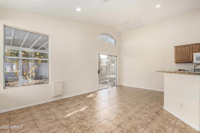 interior space with vaulted ceiling and light tile patterned flooring