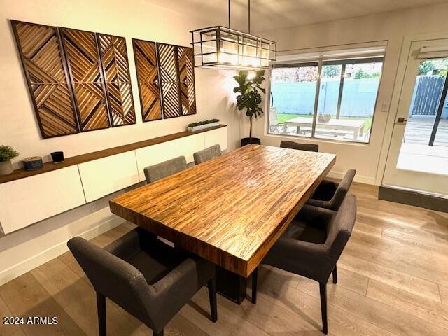 dining space featuring light hardwood / wood-style flooring and a notable chandelier