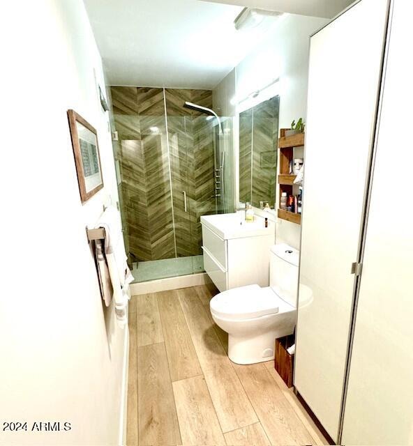 bathroom featuring vanity, a shower with shower door, toilet, and hardwood / wood-style flooring