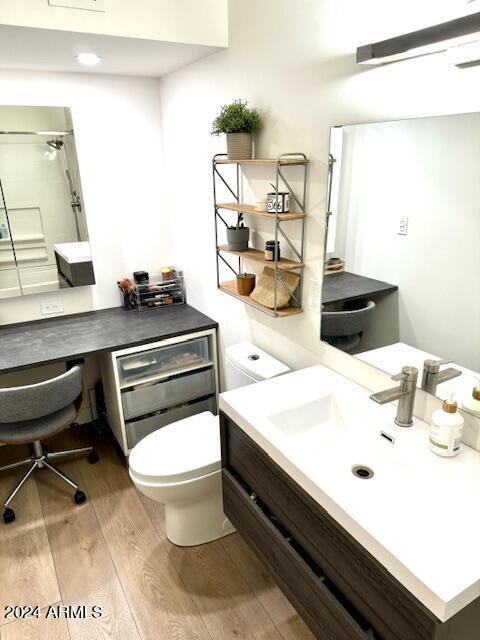 bathroom with walk in shower, toilet, vanity, and hardwood / wood-style floors