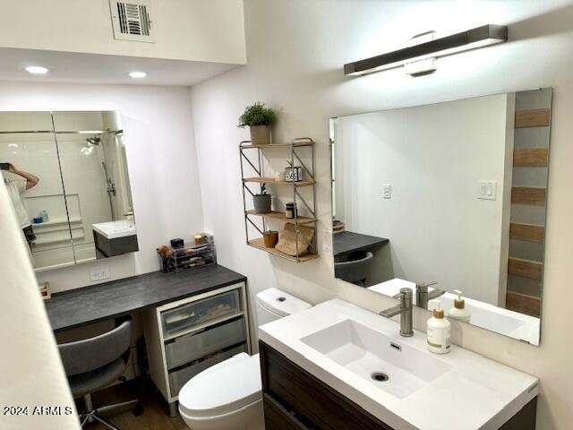 bathroom featuring a shower, vanity, and toilet