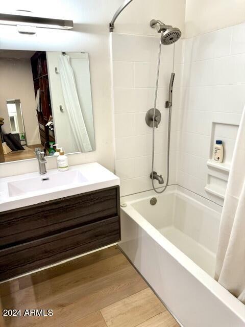 bathroom featuring wood-type flooring, vanity, and shower / bath combination with curtain