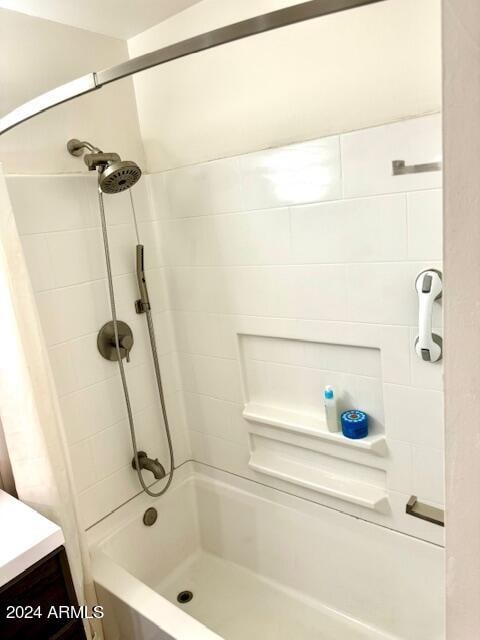 bathroom with tiled shower / bath and vanity