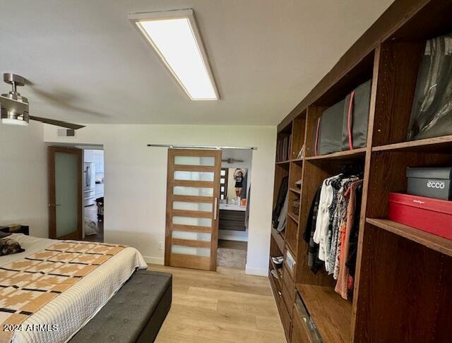 bedroom with light wood-type flooring, ceiling fan, and a closet