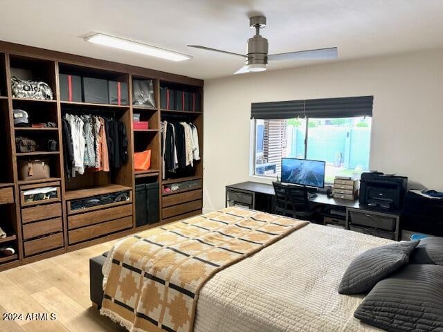 bedroom with light wood-type flooring, ceiling fan, and a closet