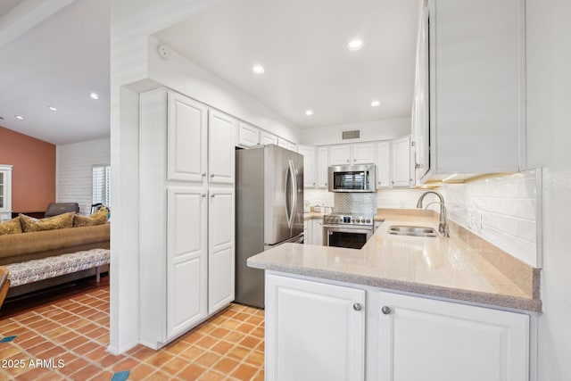 4800 N 68th St Unit 357, Scottsdale, AZ 85251 - kitchen featuring stainless steel appliances, a sink, white cabinets, tasteful backsplash, and light stone countertops
