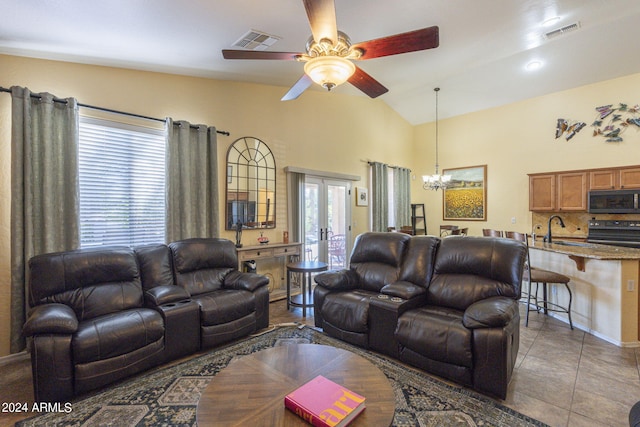 tiled living room with ceiling fan with notable chandelier, lofted ceiling, sink, and french doors