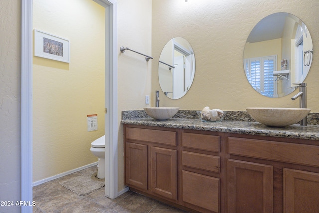 bathroom with vanity, toilet, and tile patterned floors