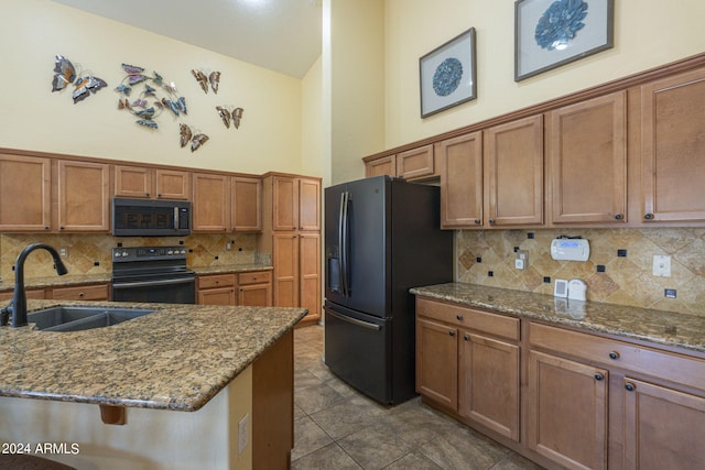 kitchen featuring stainless steel appliances, stone counters, sink, and tasteful backsplash