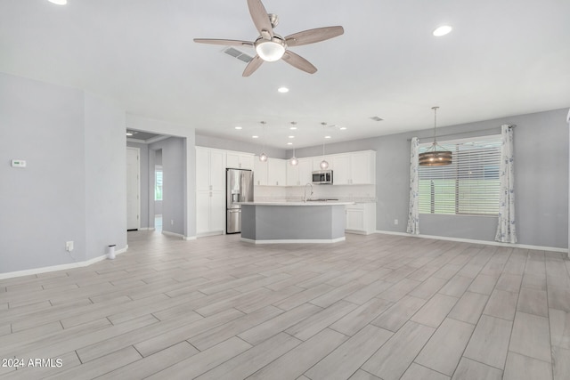 unfurnished living room with light hardwood / wood-style floors, sink, and ceiling fan