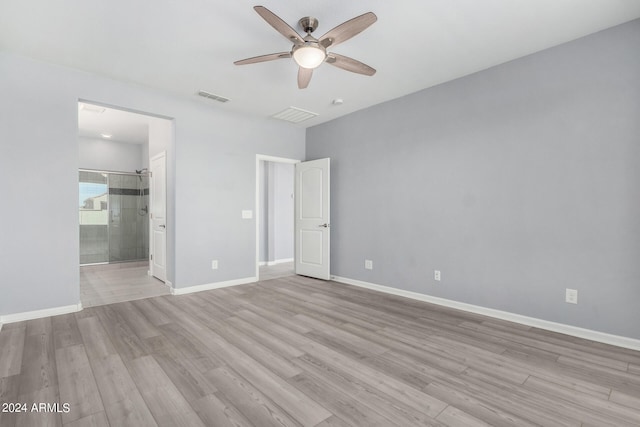 unfurnished bedroom with light wood-type flooring, ceiling fan, and ensuite bathroom