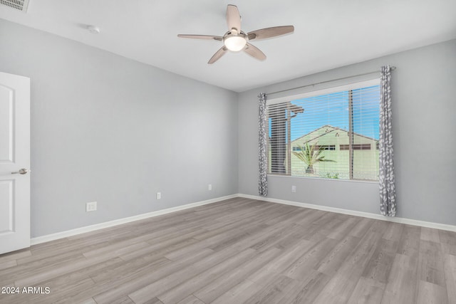 empty room with ceiling fan and light hardwood / wood-style flooring