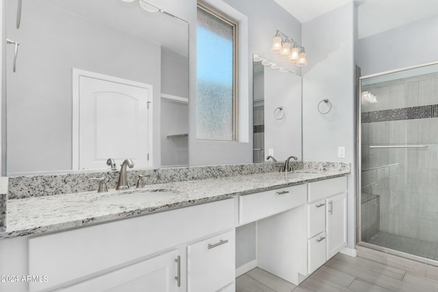 bathroom featuring wood-type flooring, vanity, and a shower with door