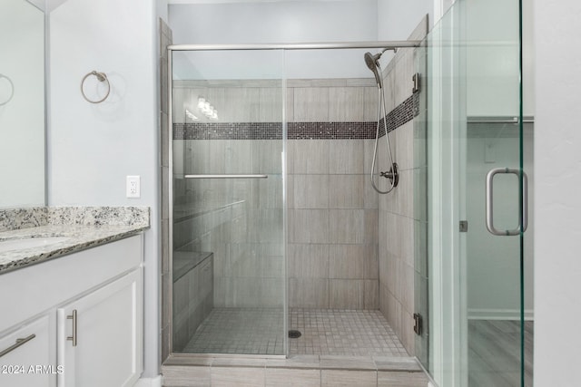 bathroom featuring walk in shower and vanity