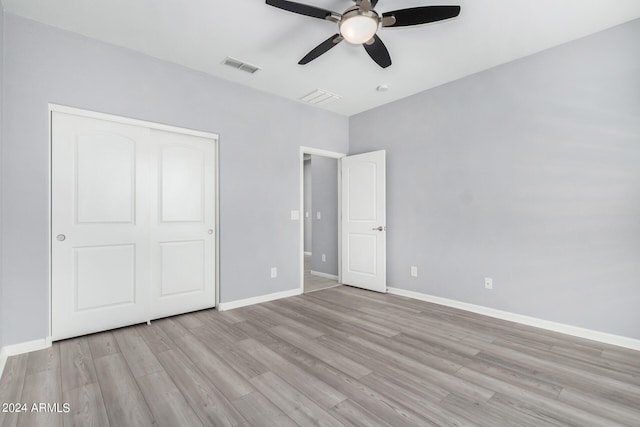 unfurnished bedroom featuring light wood-type flooring, ceiling fan, and a closet