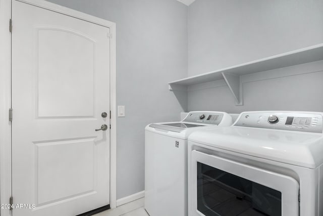 laundry area featuring light tile patterned floors and washer and clothes dryer