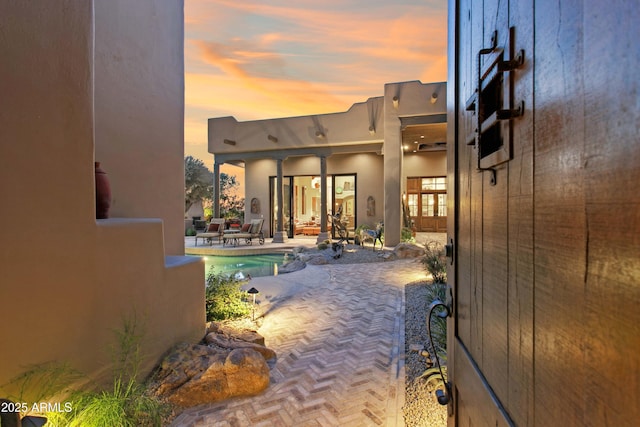 pool at dusk with a patio