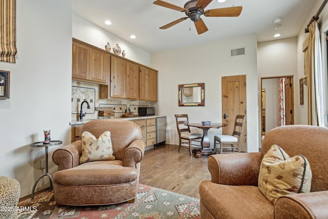 living room with ceiling fan and light wood-type flooring