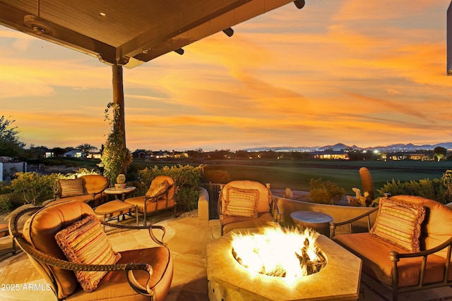 patio terrace at dusk featuring an outdoor fire pit