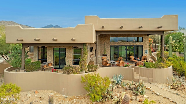 rear view of property with a mountain view and a patio area