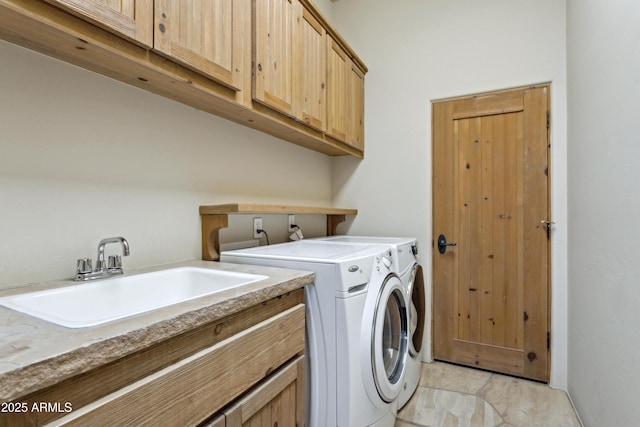 clothes washing area featuring cabinets, washing machine and dryer, and sink