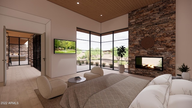 bedroom featuring light wood-type flooring, access to exterior, a towering ceiling, a stone fireplace, and wooden ceiling