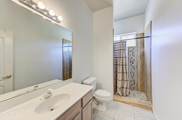 bathroom featuring toilet, walk in shower, vanity, and tile patterned flooring