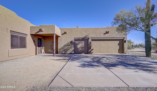 pueblo-style house featuring a garage