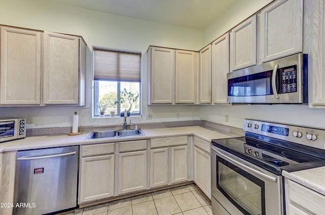 kitchen featuring light tile patterned flooring, stainless steel appliances, and sink