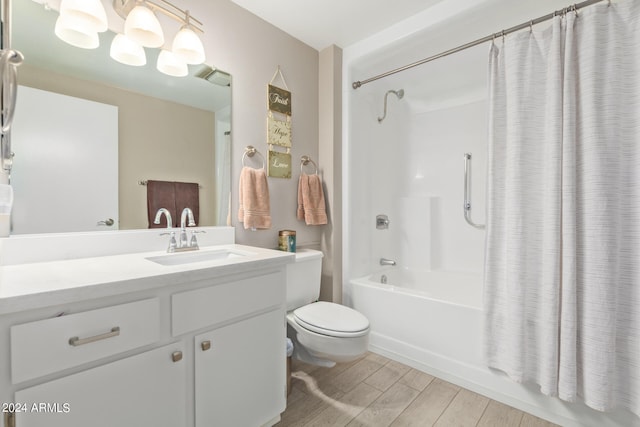 full bathroom featuring hardwood / wood-style flooring, vanity, shower / tub combo, and toilet