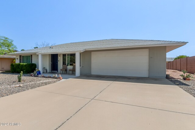 single story home featuring a garage, fence, and concrete driveway