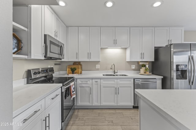 kitchen featuring appliances with stainless steel finishes, recessed lighting, white cabinetry, and a sink