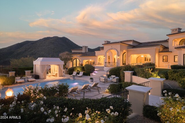 exterior space with a gazebo, a fenced in pool, a mountain view, and a patio