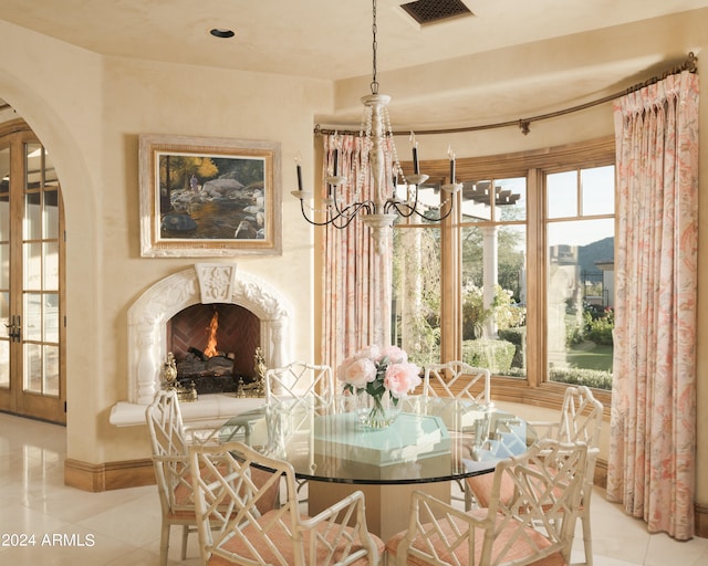 dining space featuring a fireplace, french doors, and light tile patterned flooring