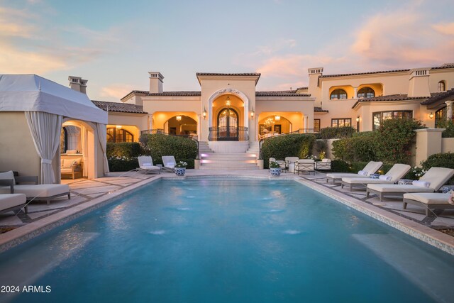 pool at dusk featuring a patio area