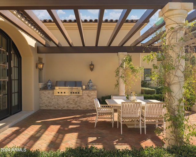 view of patio with grilling area, a pergola, and exterior kitchen