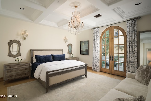 bedroom featuring coffered ceiling, an inviting chandelier, light wood-type flooring, and french doors