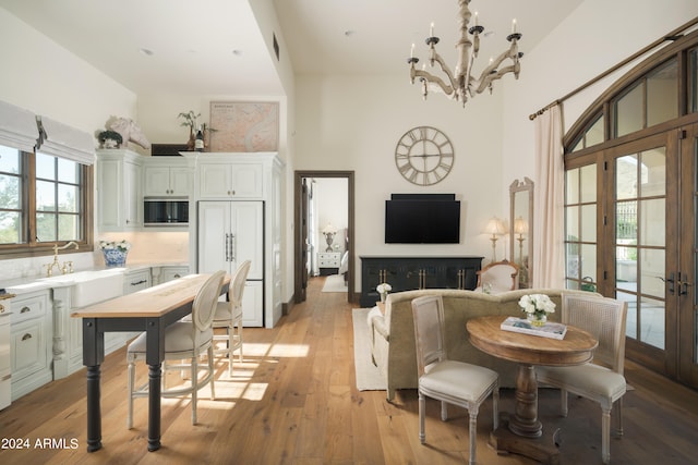 dining space featuring light hardwood / wood-style floors, a notable chandelier, and french doors