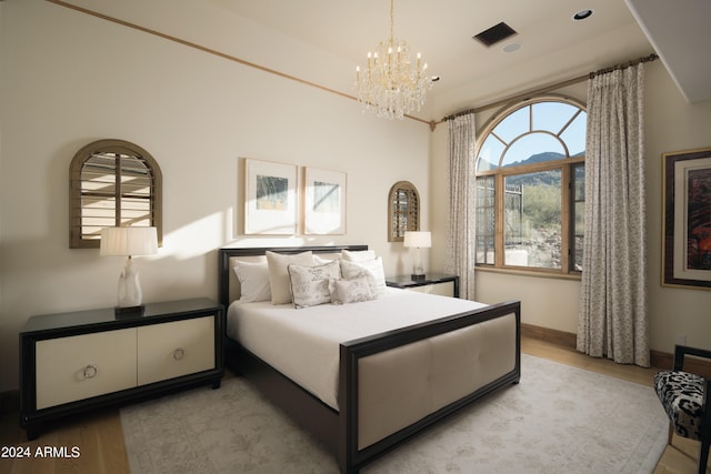 bedroom featuring a notable chandelier and light wood-type flooring