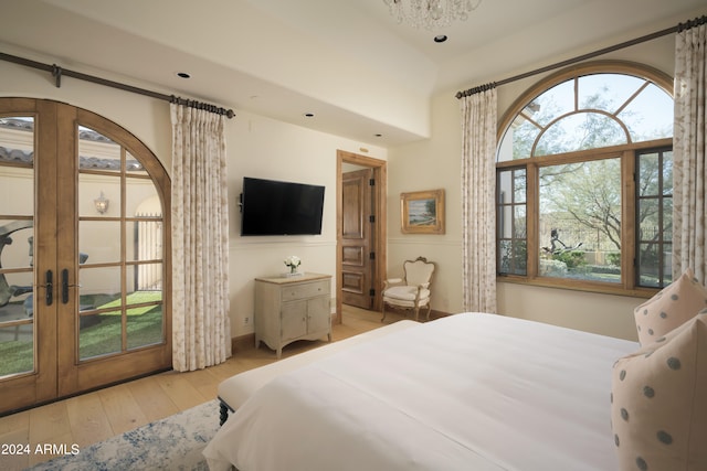 bedroom with french doors, multiple windows, and light hardwood / wood-style flooring