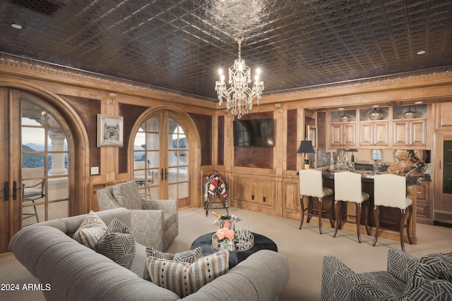 carpeted living room with a chandelier, crown molding, and french doors