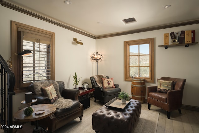 living room with light wood-type flooring and crown molding