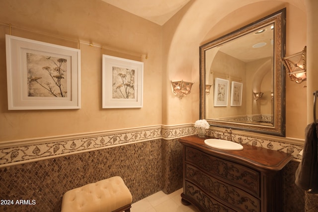 bathroom with tile walls, tile patterned flooring, and vanity