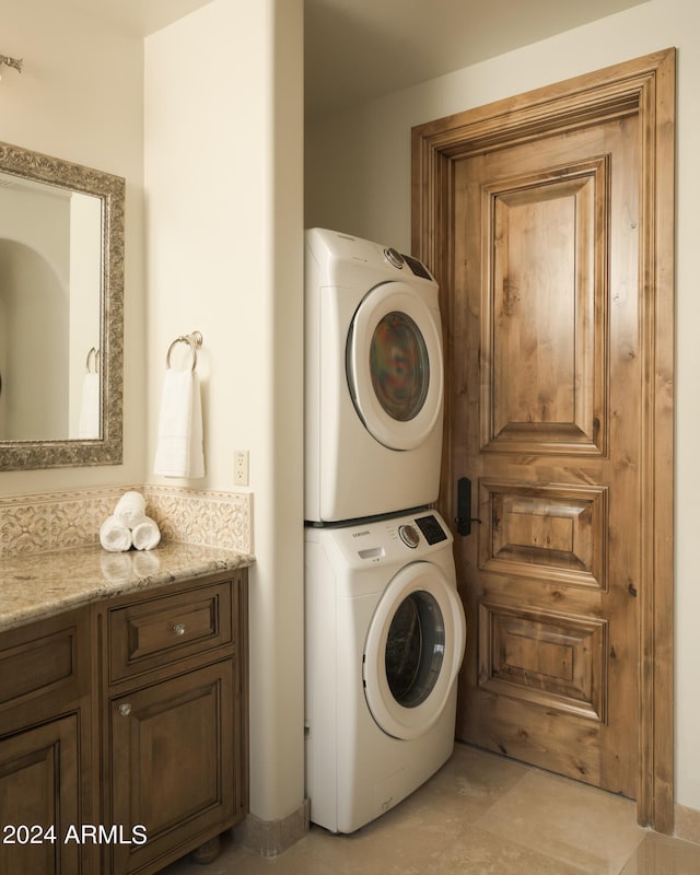 clothes washing area featuring stacked washing maching and dryer