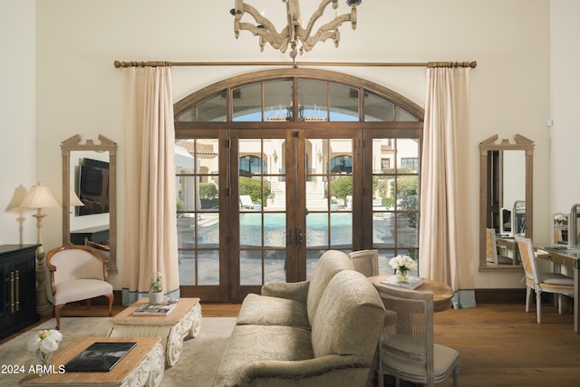 living room with hardwood / wood-style floors, a chandelier, and french doors