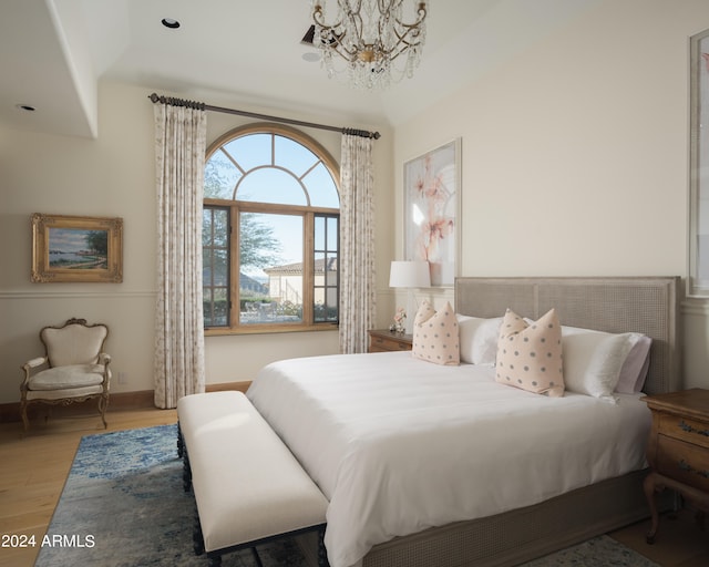 bedroom featuring light wood-type flooring and a chandelier