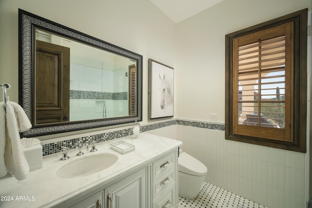 bathroom featuring tile walls, toilet, vanity, and tile patterned flooring