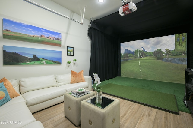 recreation room with light hardwood / wood-style flooring and golf simulator